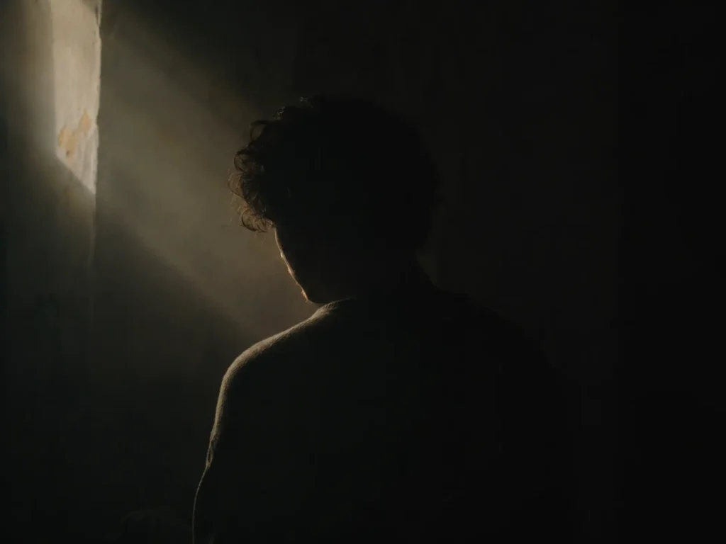 Silueta en penumbra con una única fuente de luz insinuando una narrativa oculta - Lo no mostrado puede hablar más que lo visible